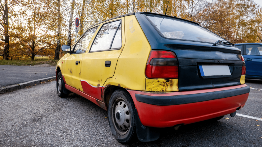 Image of yellow and red scrap vehicle in parking lot