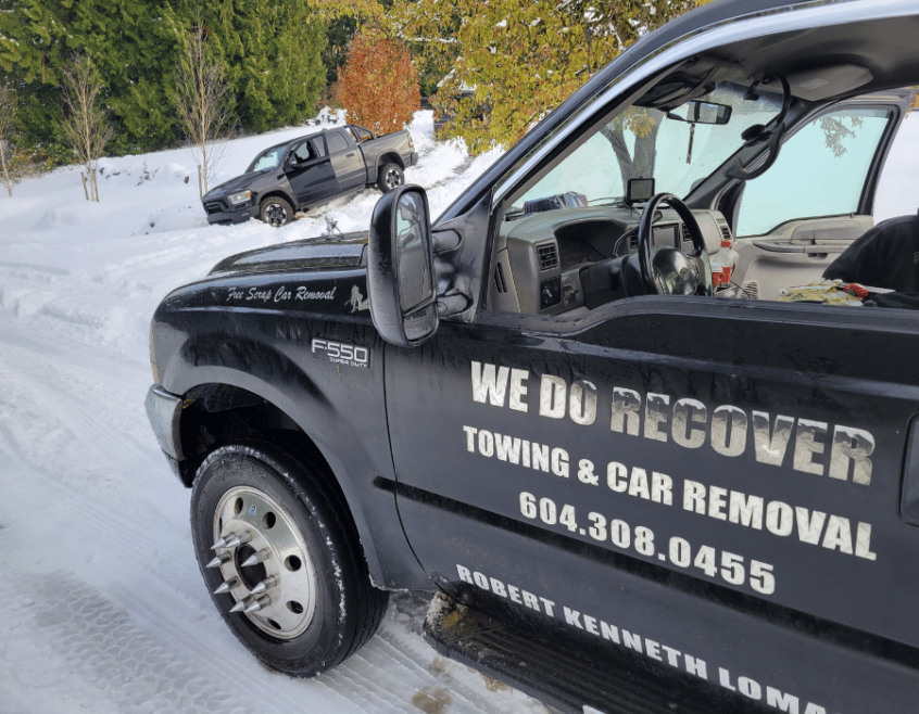 Image of "We Do Recover" tow truck on snowy road